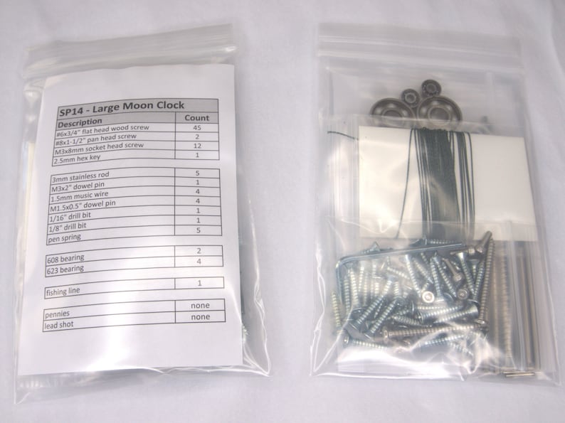 May include: A clear plastic bag containing a list of materials and their quantities needed to build a large moon clock. The list includes items like screws, dowel pins, drill bits, and fishing line. The bag also contains a separate clear plastic bag with the materials needed for the clock.