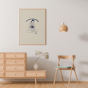 Pu&ograve; includere: Una stampa incorniciata con uno sfondo beige e un'illustrazione blu di una persona che fa la maglia. Il testo "I'd rather be knitting" &egrave; scritto in blu sopra l'illustrazione.