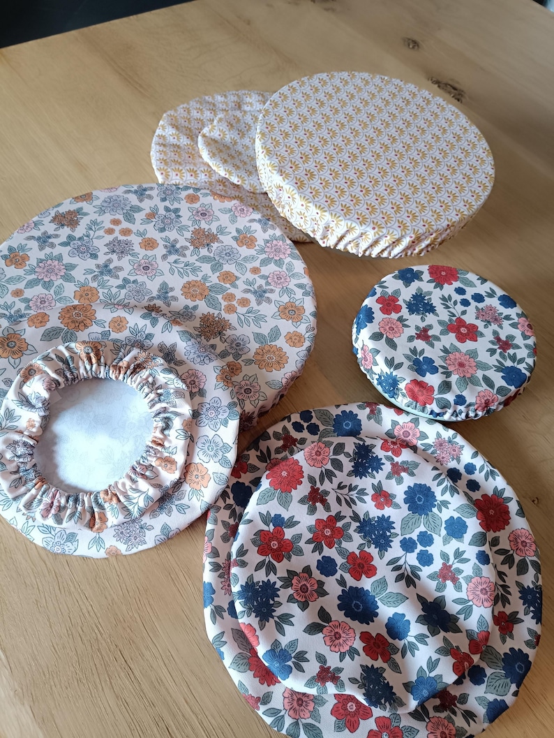 Puede incluir: Un conjunto de cubiertas reutilizables para cuencos de varios tama&ntilde;os y con estampados florales. Las cubiertas presentan una mezcla de colores, incluyendo rosa, naranja, azul y rojo, con bordes el&aacute;sticos para un ajuste seguro. La tela tiene una est&eacute;tica vintage.