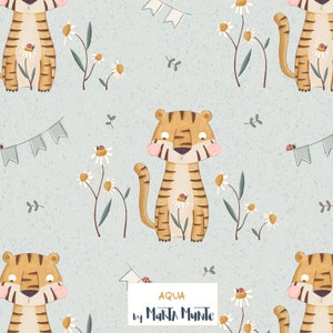 May include: A repeating pattern featuring cartoon tigers with brown stripes, pink cheeks, and daisies with ladybugs on a light blue background. Small pennant banners and sprigs of leaves complete the design. The text "AQUA by MARTA MUNTE" is in a white rectangle.