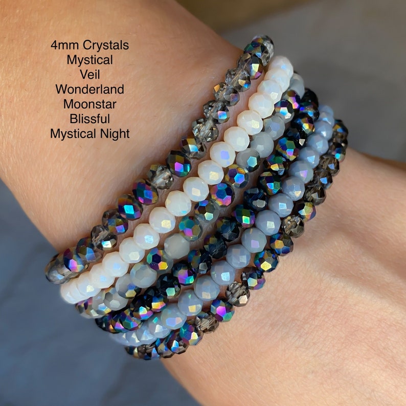 May include: A collection of beaded bracelets featuring 4mm crystals in various colors. The bracelets include shades of gray, white, and iridescent beads. Text on the image reads: 4mm Crystals, Mystical, Veil, Wonderland, Moonstar, Blissful, Mystical Night.
