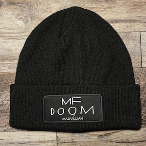 May include: Black beanie with a white patch that says "MF DOOM MADVILLIAN".