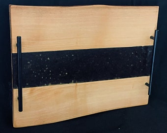Könnte beinhalten: Ein Holztablett mit schwarzem Einlegeteil und schwarzen Metallgriffen. Das Tablett hat eine natürliche Holzoptik und einen leicht abgerundeten Rand.
