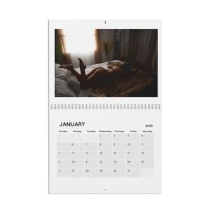 May include: A calendar for January 2025 with a photo of a person lying on a bed. The photo is in black and white.
