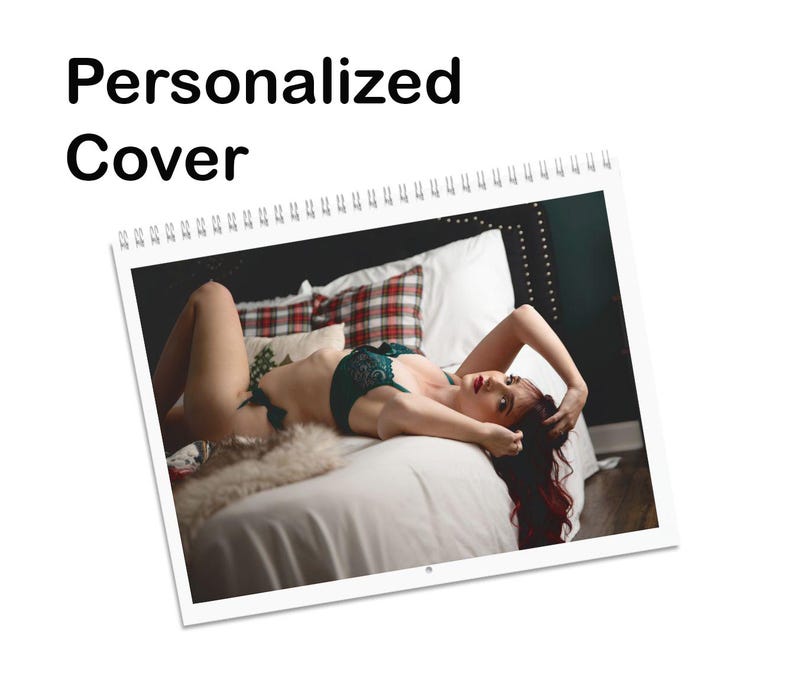 May include: A woman in green lingerie lies on a bed with a red and black plaid throw pillow. She is looking at the camera with her hair spread out around her.