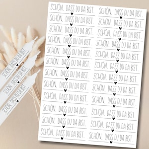 Puede incluir: Una hoja de papel blanco con texto negro que dice "SCHON, DASS DU DA BIST." repetido varias veces. Cada línea de texto tiene un pequeño símbolo de corazón.