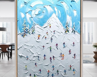 May include: A large rectangular wall art piece featuring a thick impasto oil painting of a snowy mountain landscape. The scene depicts numerous small figures skiing down a white slope under a bright blue sky with swirling clouds and pine trees.