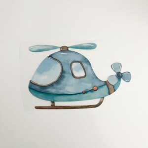 Könnte beinhalten: Eine blaue und grüne Aquarell-Illustration eines Hubschraubers mit einem braunen Propeller und einem kleinen Fenster. Der Hubschrauber befindet sich auf einem weißen Hintergrund.