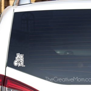May include: White car with a black window sticker that says "Play Like a Girl" on the back window.