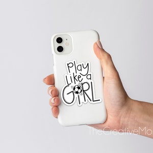 May include: White phone case with a black and white sticker that says "Play like a girl" with a soccer ball graphic.