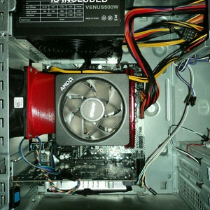 May include: Inside view of a computer case with a red duct, a black power supply unit with the text "VENUS500W" and a motherboard with an AMD CPU cooler.