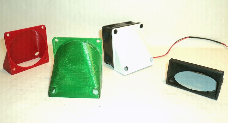 May include: An assortment of 3D-printed electronic components in red, green, black, and white. The components include angled housings and a small display screen. Some have mounting holes and wires.