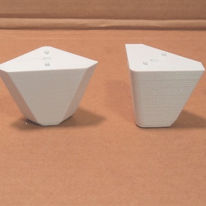 Puede incluir: Cuatro soportes de esquina de pl&aacute;stico blanco, cada uno con tres agujeros, dise&ntilde;ados para sostener las patas de los muebles.