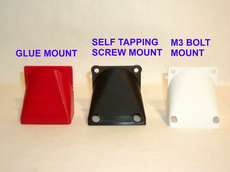 Puede incluir: Tres soportes de ventilador impresos en 3D en rojo, negro y blanco. Los soportes est&aacute;n etiquetados como "Glue Mount", "Self Tapping Screw Mount" y "M3 Bolt Mount".