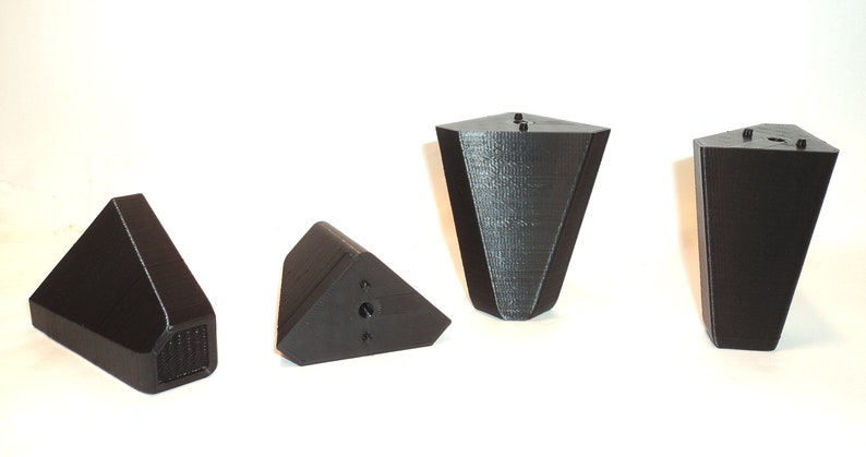 Puede incluir: Cuatro patas de muebles triangulares negras con un agujero para tornillo en la parte inferior. Las patas est&aacute;n hechas de un material texturizado y tienen una forma ligeramente redondeada.