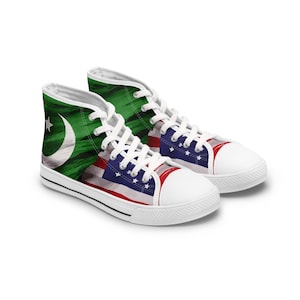 May include: A pair of white high-top canvas shoes with a green and white Pakistani flag design on one shoe and a red, white, and blue American flag design on the other shoe.