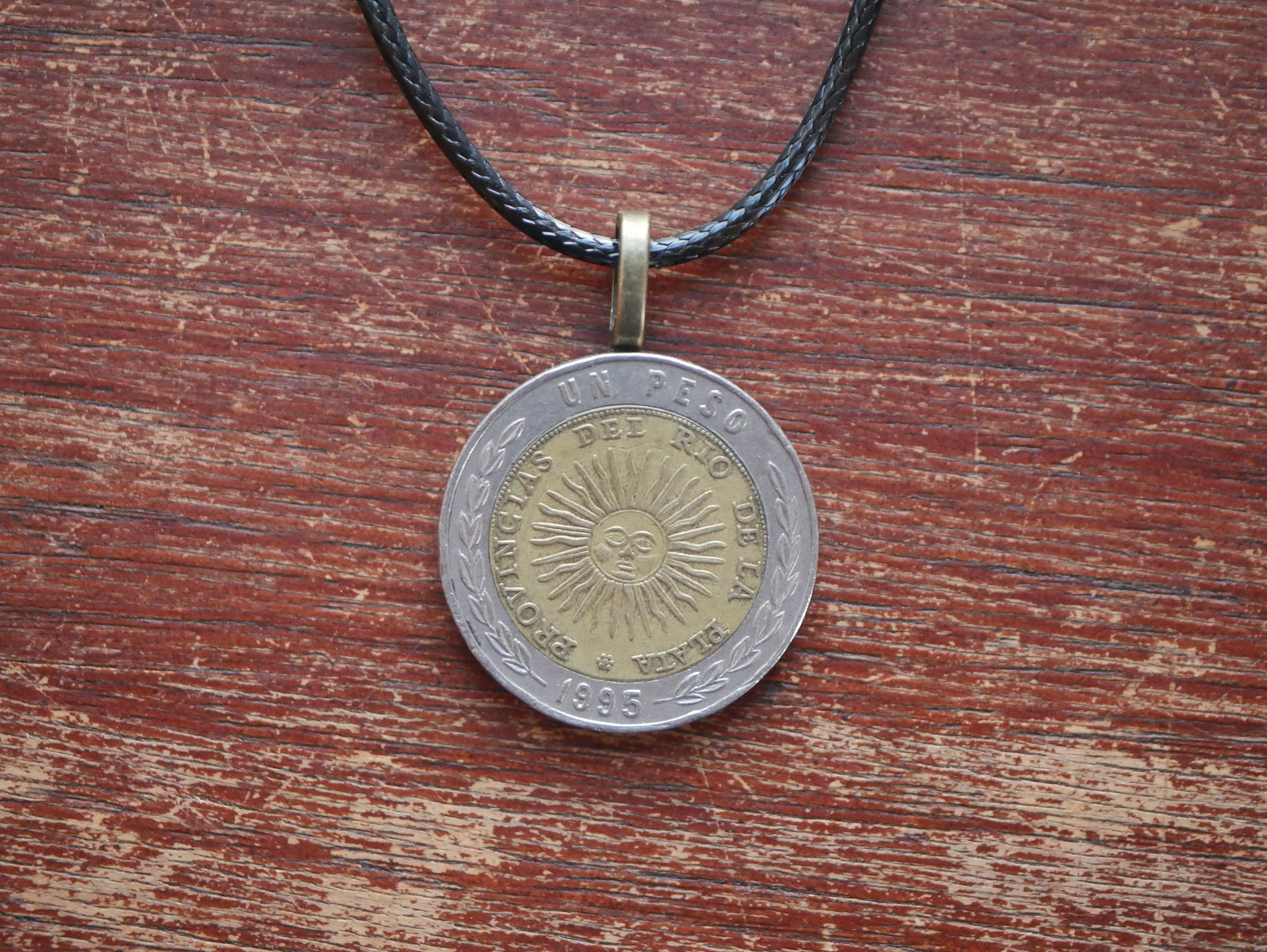 アルゼンチンの太陽コインネックレス:革紐のバイメタルペンダント