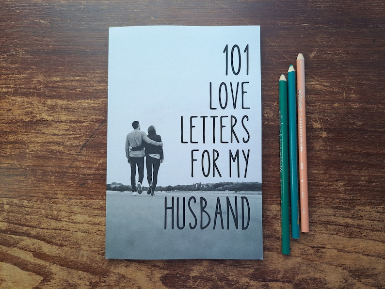 Puede incluir: Una foto en blanco y negro de una pareja caminando de la mano por un camino. La portada del libro dice "101 cartas de amor para mi marido".
