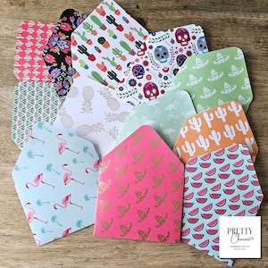 May include: A collection of colourful patterned envelopes featuring various designs, including flamingos, pineapples, cacti and sombreros. The envelopes are ideal for adding a festive touch to any occasion.