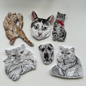 Op de afbeelding: Zes geborduurde patches met verschillende katten en een hond. De patches zijn wit met zwarte contouren en tonen realistische afbeeldingen van de dieren.