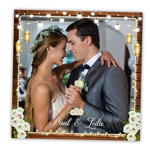 Könnte beinhalten: Ein Hochzeits-Fotobooth-Hintergrund mit rustikalem Holzmaserungshintergrund, weißen Lichterketten und goldenen Laternen. Das Paar ist in festlicher Kleidung gekleidet und steht vor dem Hintergrund. Der Text "Paul & Leila" ist unten auf dem Hintergrund in Kursivschrift geschrieben.