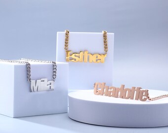 Puede incluir: Tres collares de oro, plata y oro rosa con placas de nombre personalizadas. Los collares llevan los nombres "Esther", "Mila" y "Charlotte".