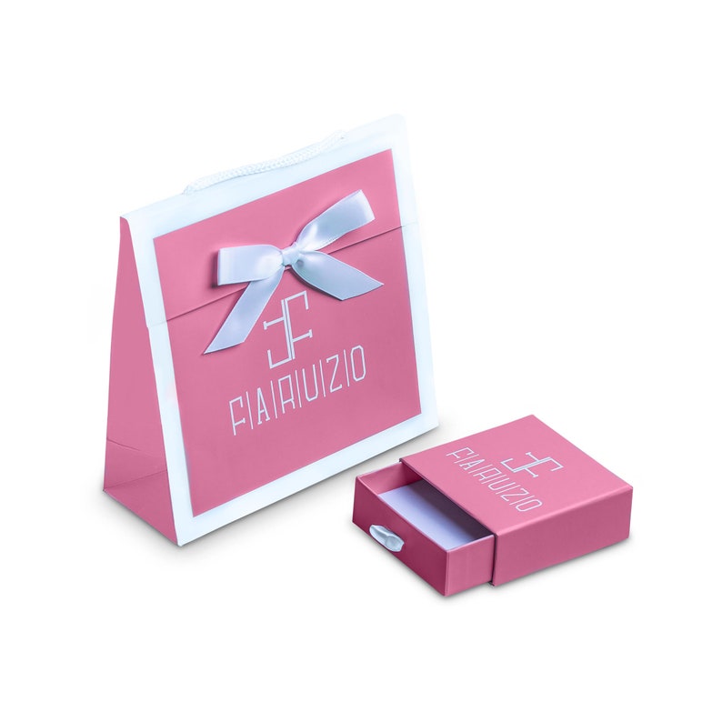 May include: A pink gift bag with a white bow and the text "FIAMRUIZIO" in white. A smaller pink box with a white drawer and the same text is in the foreground.