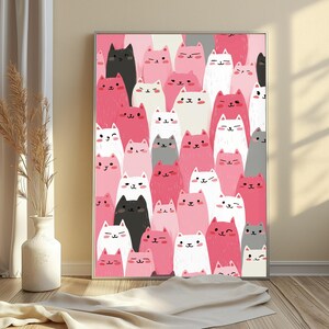 May include: A rectangular wall art print featuring a dense, repeating pattern of stylized cartoon cats in various shades of pink, white, gray, and black. Each cat has a simple facial expression with eyes and a small mouth, arranged in a vertical stack.