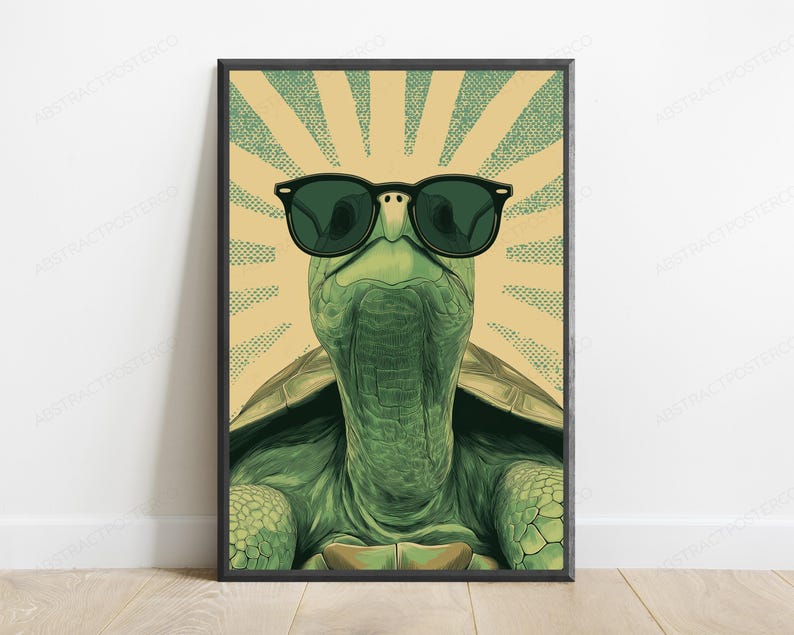May include: A framed wall art print featuring a green turtle wearing black sunglasses. The turtle is centered against a background of radiating light beige and green dotted sunburst lines. The illustration has a detailed texture on the skin.