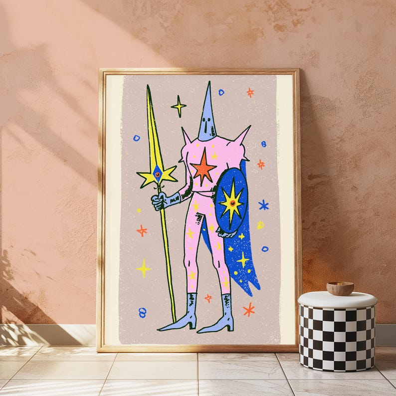 May include: A framed art print featuring a stylised figure in a pink suit with a tall pointed headpiece, holding a long yellow spear and a blue shield. The background is light beige with scattered colourful stars and small circular shapes.