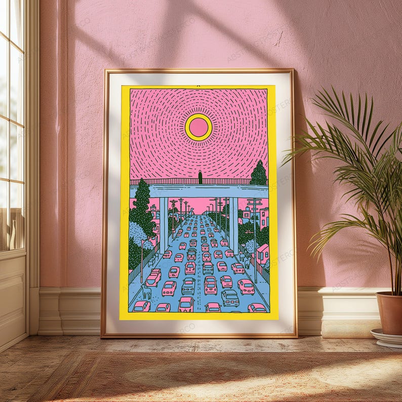 May include: A framed art print featuring a stylized illustration of a busy highway with many cars under a bridge. A bright yellow sun sits in a pink sky with radiating lines. The scene includes green trees and blue structural elements.