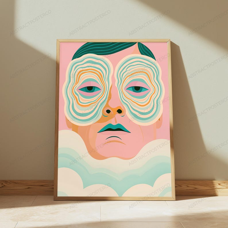 May include: A framed art print featuring a stylized portrait of a person with pink skin, dark hair, and teal lips. The eyes are surrounded by concentric, wavy, circular patterns in shades of teal, orange, and cream. The bottom features light blue clouds.