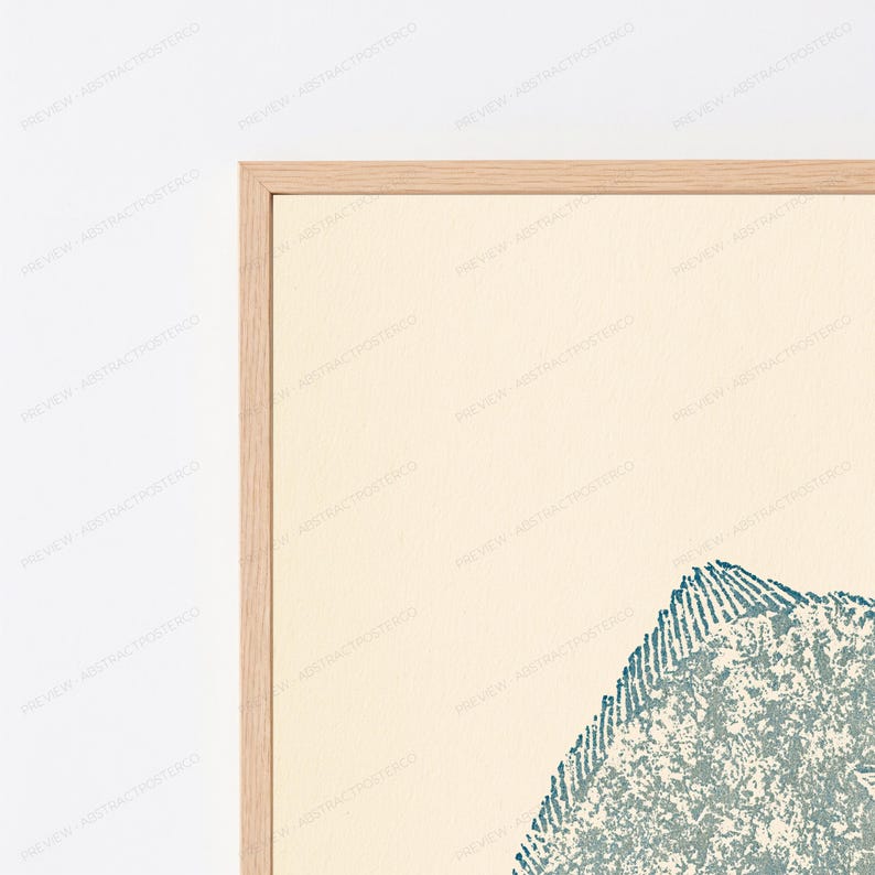 May include: A framed wall art print featuring a textured, teal-colored abstract shape with a pointed top edge, set against a solid cream-colored background. The artwork is enclosed within a light-toned wooden frame with a clean, simple border.