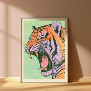 Może przedstawiać: Oprawiony wydruk ścienny przedstawiający ilustrację w stylu pop-art ryczącego tygrysa. Tygrys jest przedstawiony w odcieniach pomarańczu, czerni i jasnego fioletu na teksturowanym jasnozielonym tle, z wykorzystaniem widocznego wzoru p&oacute;łton&oacute;w.