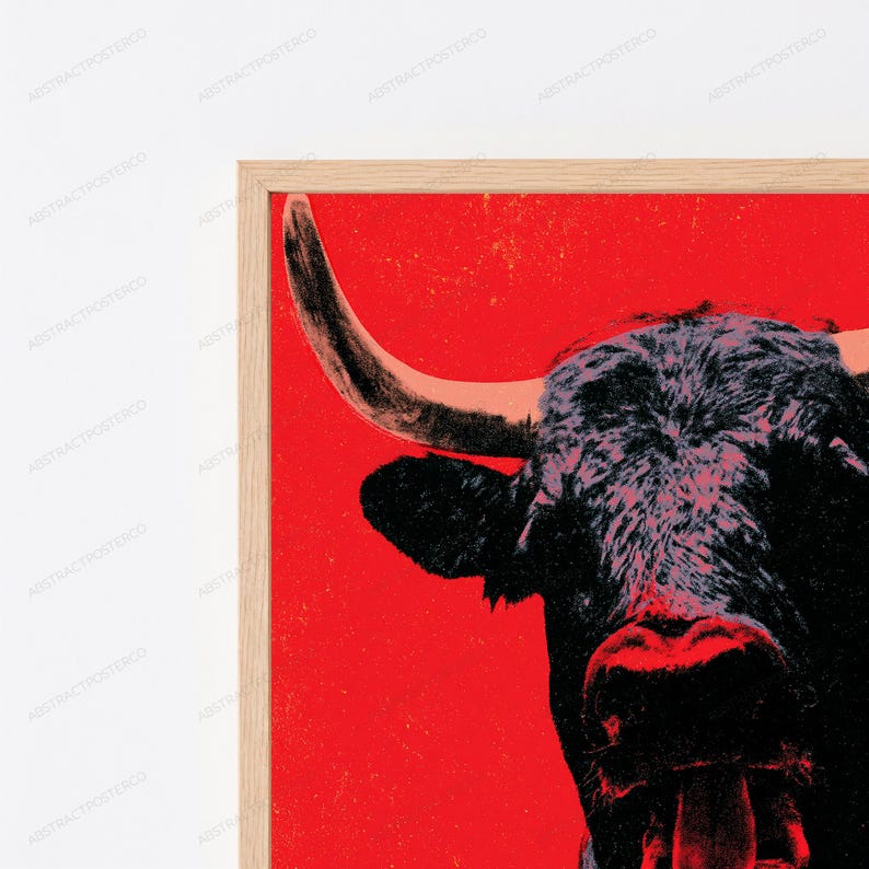 K&ouml;nnte beinhalten: Ein gerahmter Wandkunstdruck mit einem kontrastreichen, stilisierten schwarzen Bullenkopf vor einem leuchtend roten Hintergrund. Der Stier ist im Profil mit einem markanten, geschwungenen Horn und strukturiertem dunklen Fell in einem hellen Holzrahmen dargestellt.