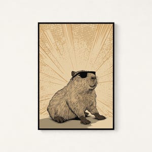 May include: A framed wall art print featuring a detailed illustration of a brown capybara wearing black sunglasses. The capybara is positioned in the center against a light tan background with radiating comic-style sunburst lines in a darker shade.