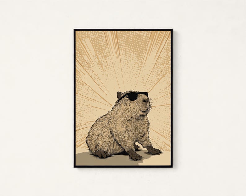 May include: A framed wall art print featuring a detailed illustration of a brown capybara wearing black sunglasses. The capybara is positioned in the center against a light tan background with radiating comic-style sunburst lines in a darker shade.