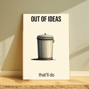 K&ouml;nnte beinhalten: Ein rechteckiger Wandkunstdruck auf cremefarbenem Hintergrund mit einer zentrierten Illustration eines grauen Metallm&uuml;lleimers mit Deckel. Der Text "OUT OF IDEAS" ist oben schwarz gedruckt, der Text "that'll do" unten schwarz gedruckt.