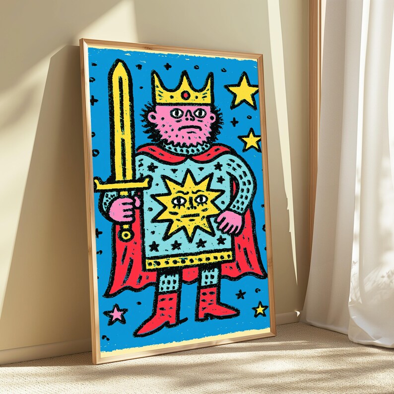 May include: A framed wall art print featuring a stylized illustration of a king with a pink face, wearing a yellow crown and a light blue tunic decorated with a large yellow sun and black stars, holding a yellow sword with a red cape.