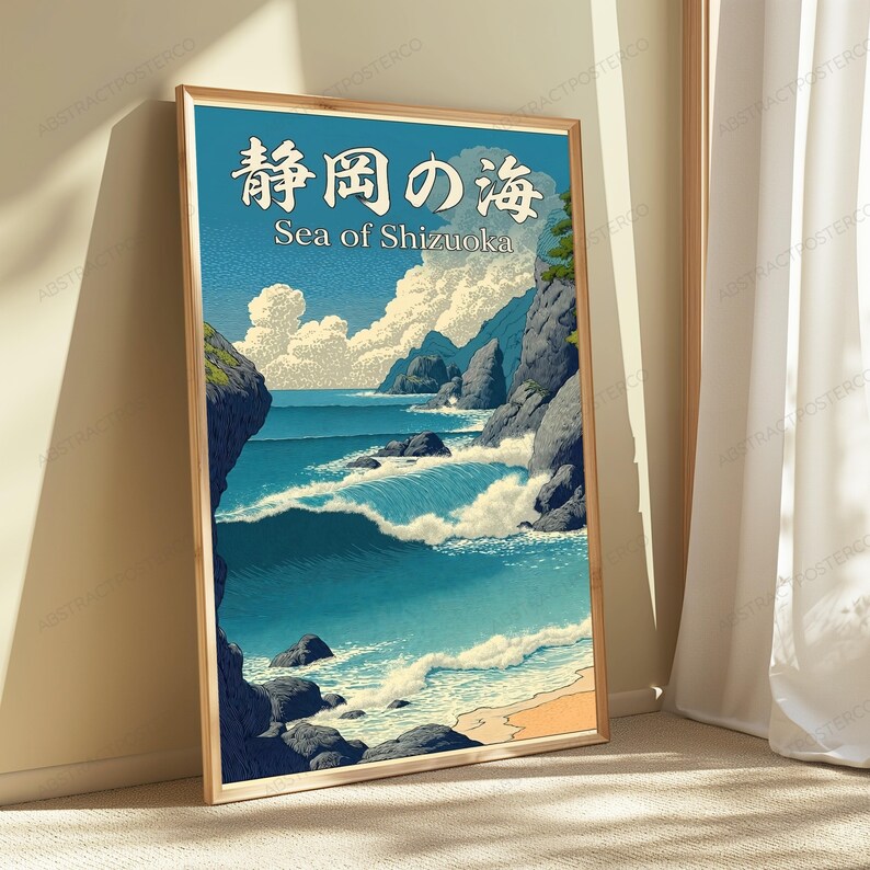 Puede incluir: Una impresi&oacute;n de arte mural vertical enmarcada que representa un paisaje costero con olas azules rompiendo contra acantilados rocosos bajo un cielo nublado. El texto en la parte superior dice 静岡の海 y Sea of Shizuoka en letras blancas. Se ve una playa.