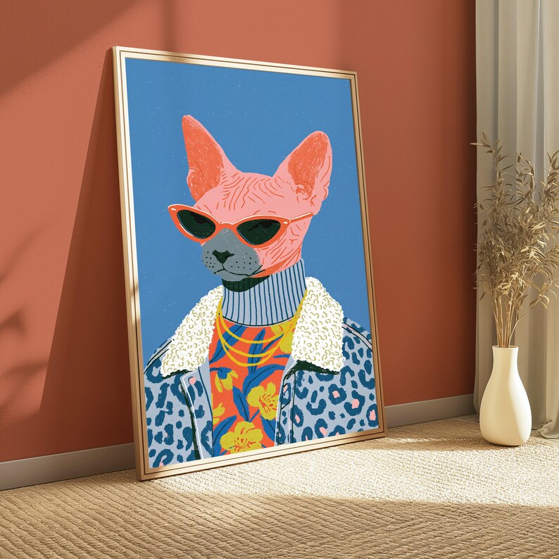 Puede incluir: Una l&aacute;mina de arte vertical enmarcada que muestra un gato Sphynx rosa con gafas de sol rojas de ojo de gato, un cuello alto gris, una cadena dorada y una chaqueta azul con estampado de leopardo y cuello de borreguito blanco sobre fondo azul.