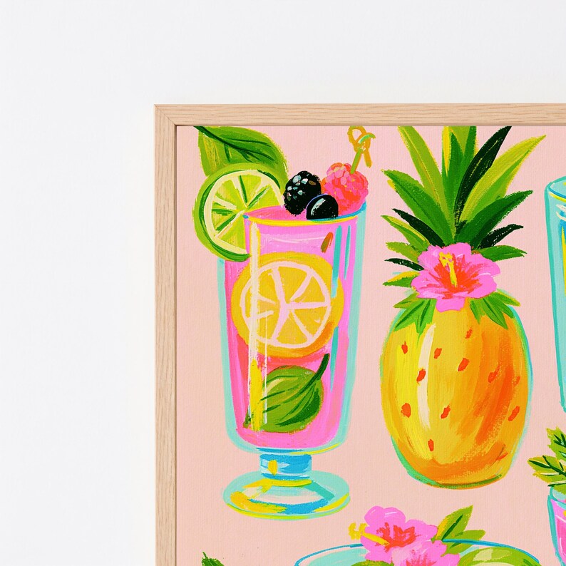 K&ouml;nnte beinhalten: Ein gerahmter Kunstdruck auf hellrosa Hintergrund mit einem hohen Glas, gef&uuml;llt mit einem rosa Getr&auml;nk, einer Limettenscheibe, einer Brombeere und einer Himbeere. Daneben steht eine gelbe Ananas mit einer leuchtend rosa Hibiskusbl&uuml;te.