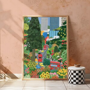May include: A framed art print depicting a vibrant urban landscape with a winding road filled with red double-decker buses, yellow taxis, and blue cars. The scene is surrounded by lush green trees, colorful flowers, and tall city buildings.