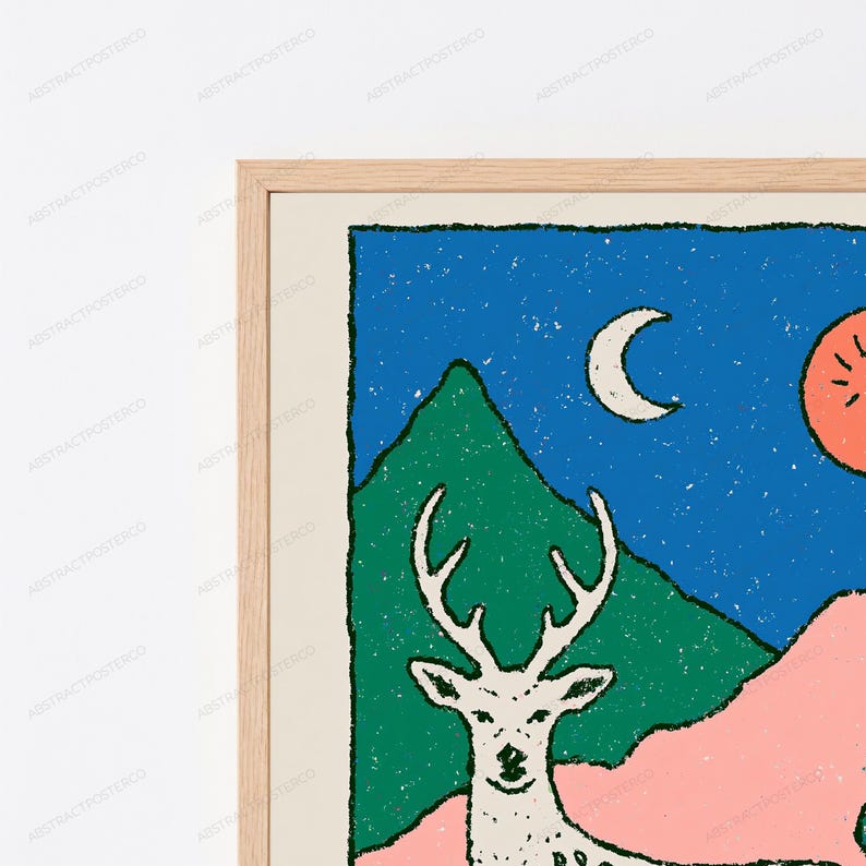 May include: A framed wall art print featuring a white deer silhouette against a landscape of green mountains and a pink foreground. The scene is set under a dark blue night sky with a white crescent moon and a large orange sun or celestial orb.