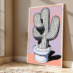May include: A framed wall art print featuring a pixelated cactus in a pot. The cactus is rendered in black and white with a stippled texture. The background is a split design of light purple and peach orange, with a dark shadow cast to the right.
