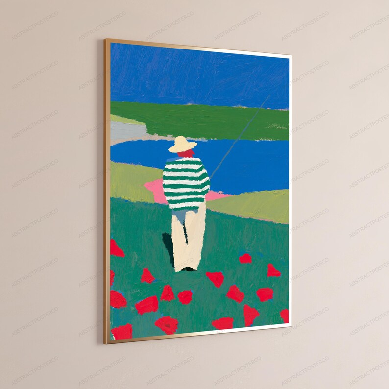 Op de afbeelding: Een ingelijste verticale kunstdruk met een gestileerd schilderij van een persoon met een strooien hoed en een groen-wit gestreept shirt met een lichte broek, staand in een groen veld met rode bloemen uitkijkend over een blauw wateroppervlak.