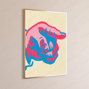 May include: A rectangular wall art print featuring a stylised graphic of a hand pointing downwards. The design uses a vibrant colour palette of bright pink, light pink, and electric blue against a textured, pale cream-coloured background.