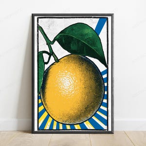 May include: A framed wall art print featuring a stylized yellow orange with green leaves on a stem. The background displays a vibrant blue and yellow sunburst pattern with a distressed, vintage-inspired halftone dot texture throughout the image.
