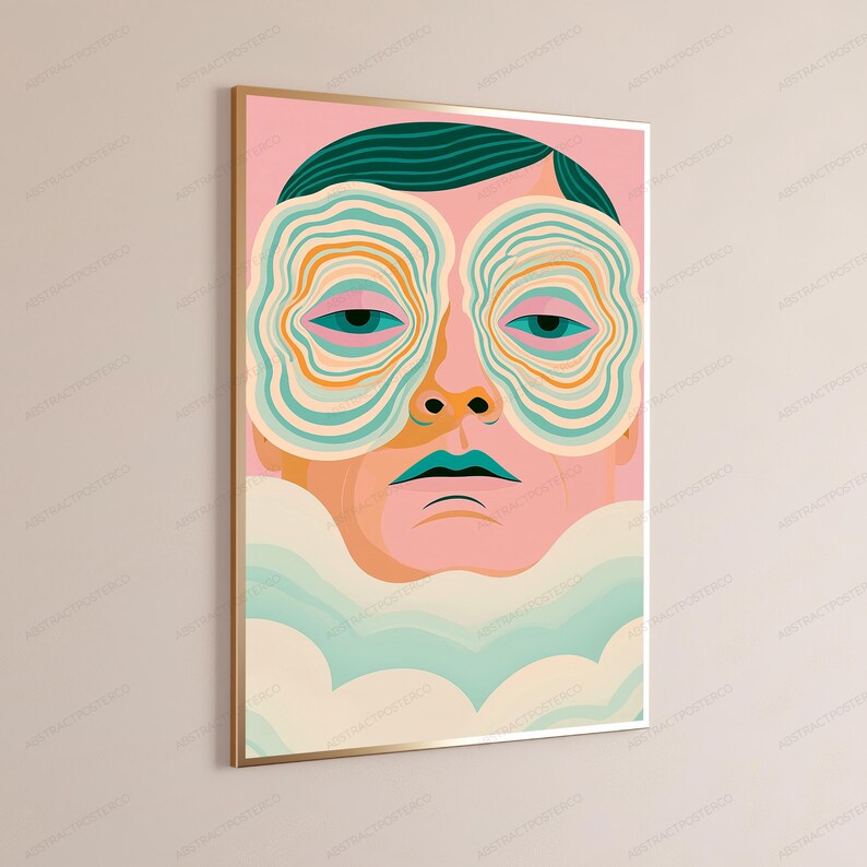 May include: A framed wall art print featuring a stylized human face with dark teal hair. The eyes are surrounded by concentric, wavy orange and teal circular patterns. The lips are teal, and the lower portion of the face is obscured by soft, light-colored clouds.