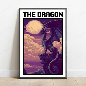 May include: A framed poster featuring pixel art of a dark purple dragon perched on a rocky cliff against a backdrop of a large pale moon and clouds. The text THE DRAGON is printed in a bold black pixelated font at the top of the artwork.